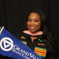 GradFest attendee holding up gvsu flag for a picture